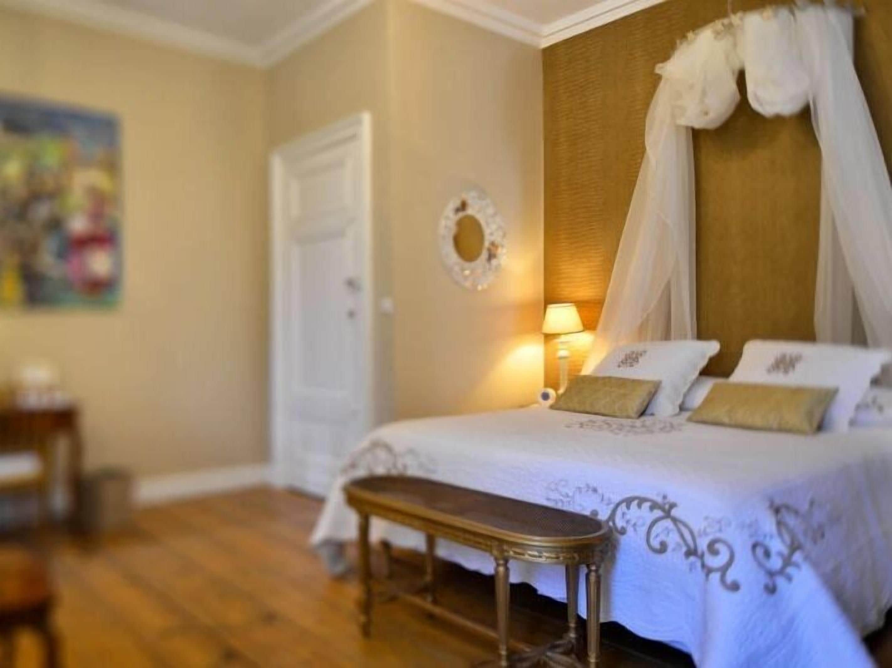 A bedroom with a bed, bedside table, and a lamp.