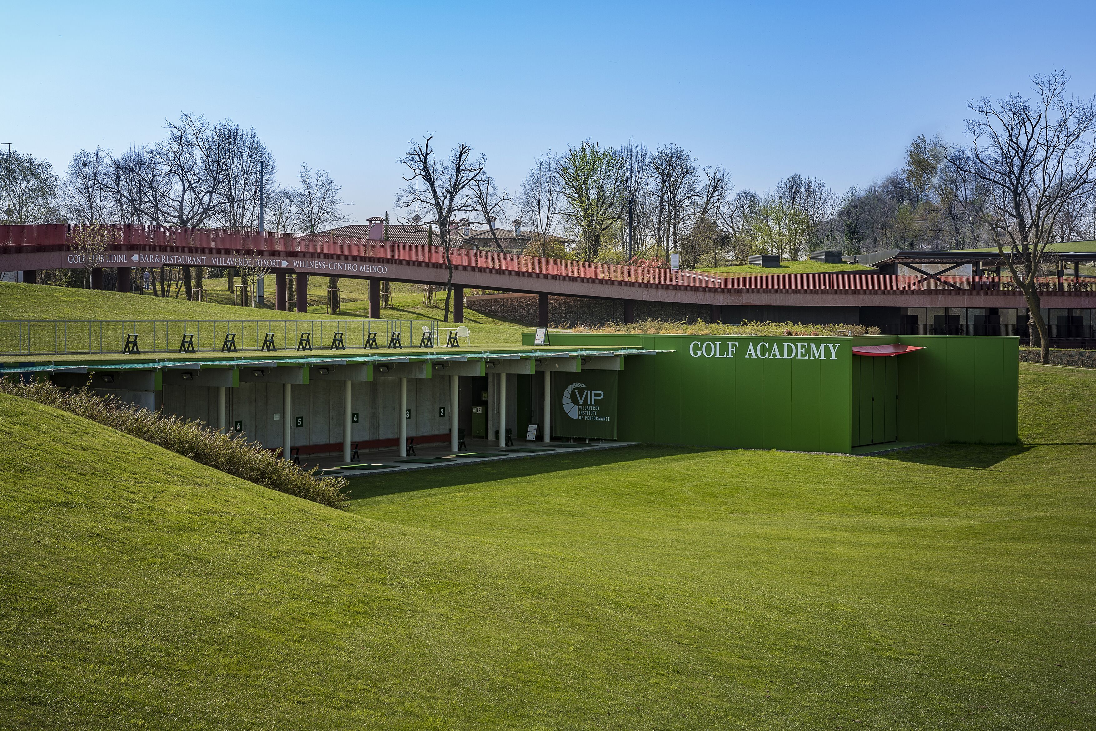 Edificio di una scuola di golf, con area di pratica coperta e lounge VIP.