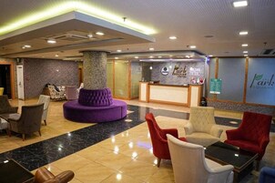 Un vestíbulo de hotel con mostrador de recepción, asientos cómodos y un suelo pulido.