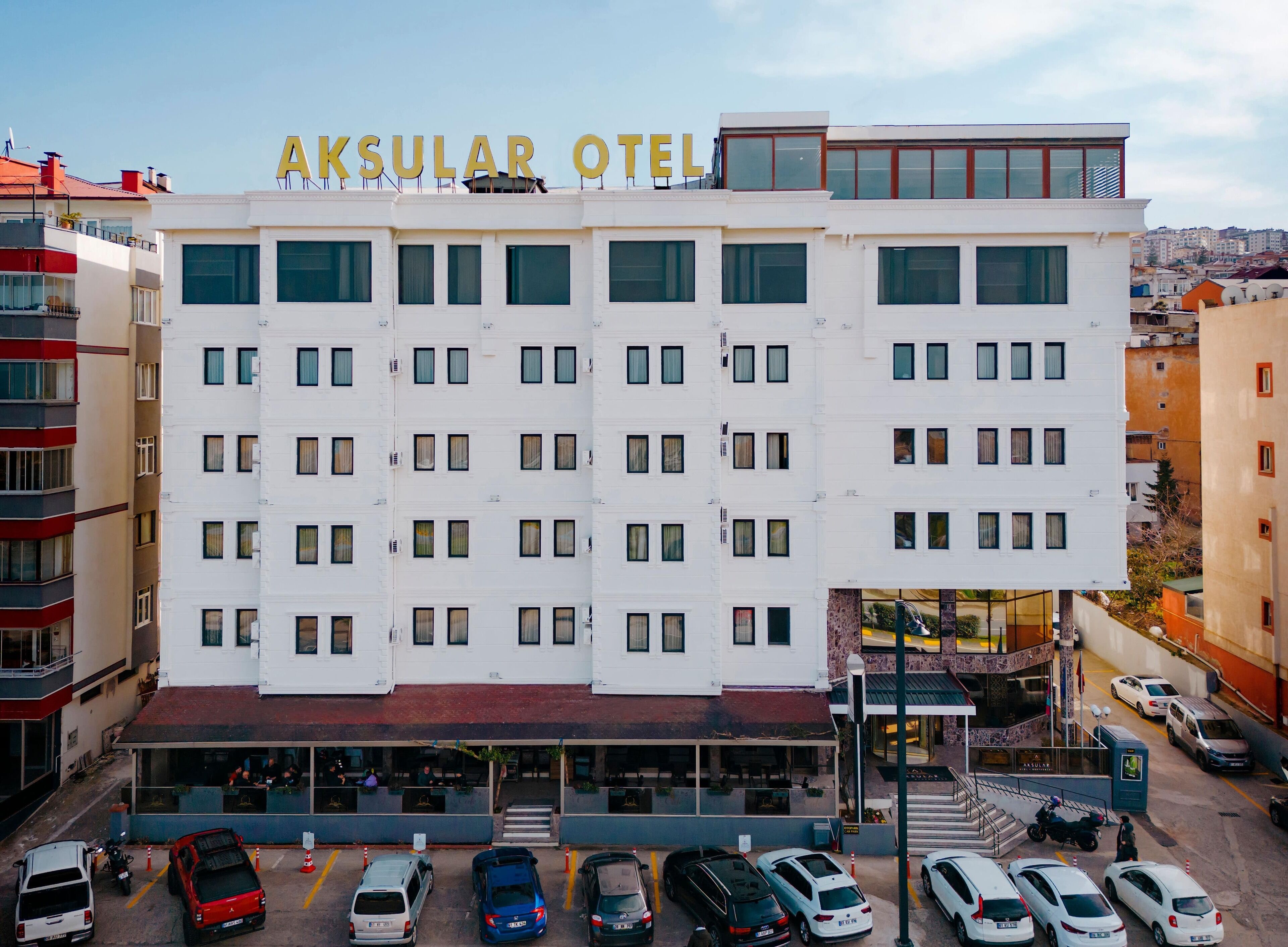 Un hôtel à plusieurs étages, reconnaissable à son enseigne bien visible indiquant « AKSULAR OTEL ».