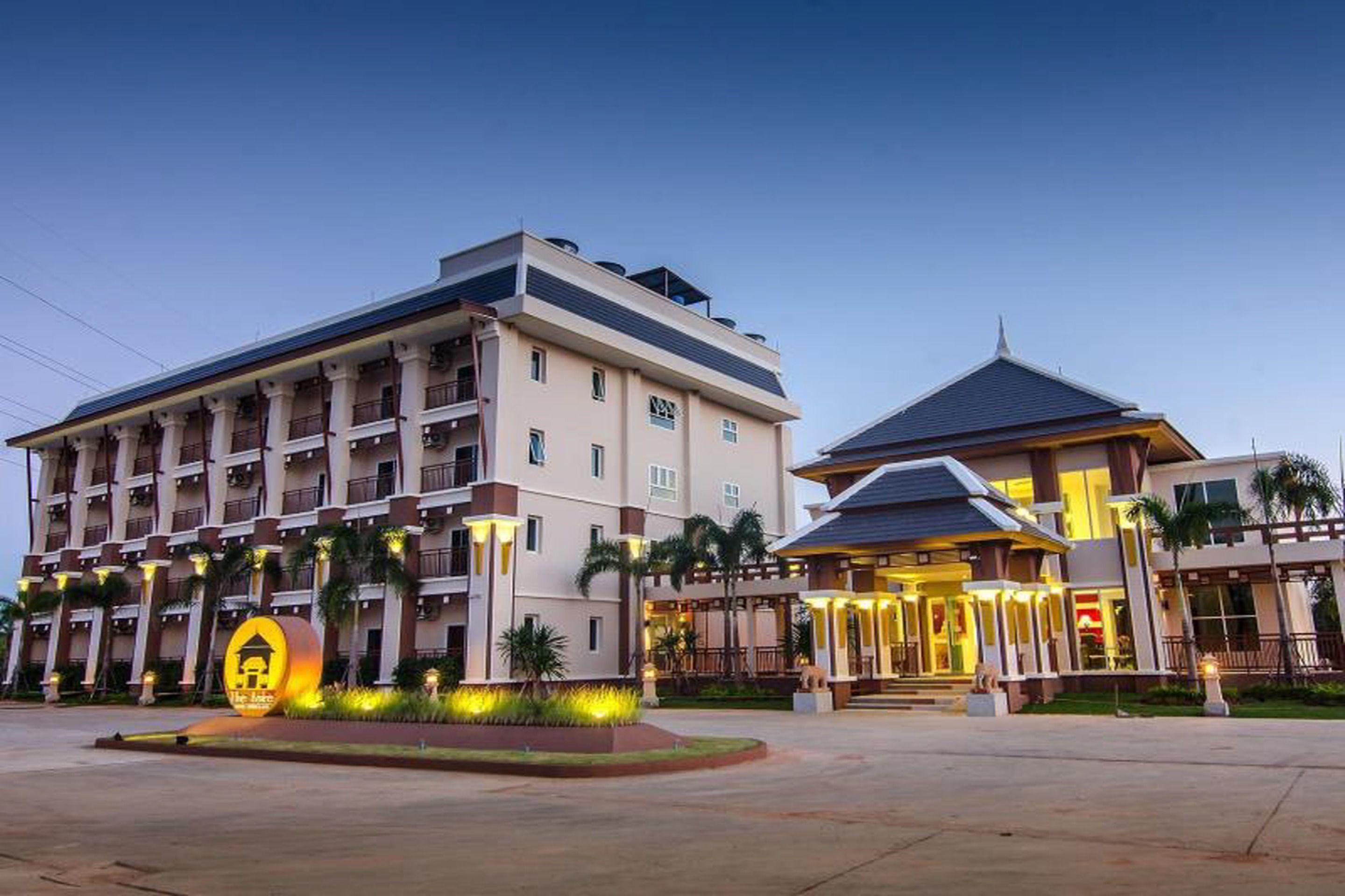 Un hotel con varios pisos, un patio central e ingreso bien iluminado.