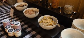 A breakfast buffet with various cereals and yogurt cups. - Pensiun Aldier (Scuol)