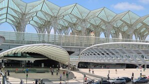 A modern architectural structure with a unique roof design and a spacious plaza area. - Oriente Rio Apartments by APT IIN - Parque das Nações (Lisbon)
