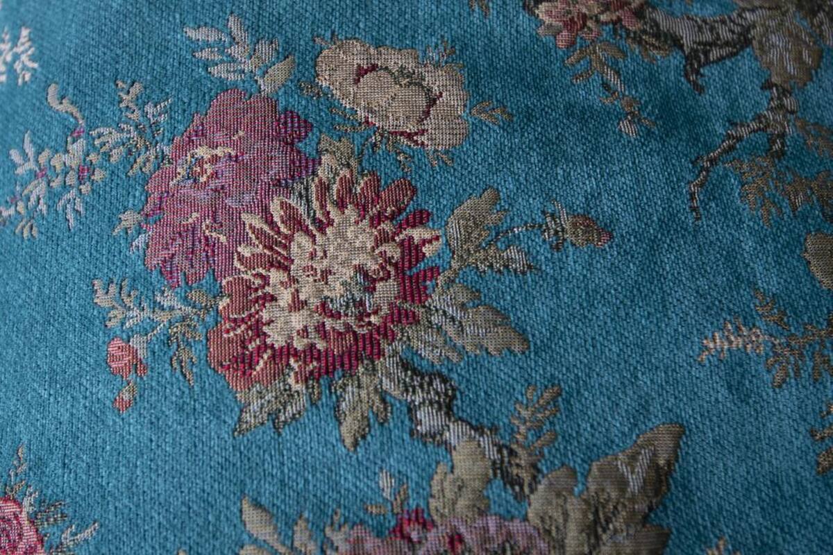 A close-up of a blue fabric with a floral pattern.