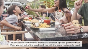 A group of people dining outdoors at a restaurant with various dishes and drinks on the table. - Oriente Marina Apartments by APT IIN - Parque das Nações (Lisbon)