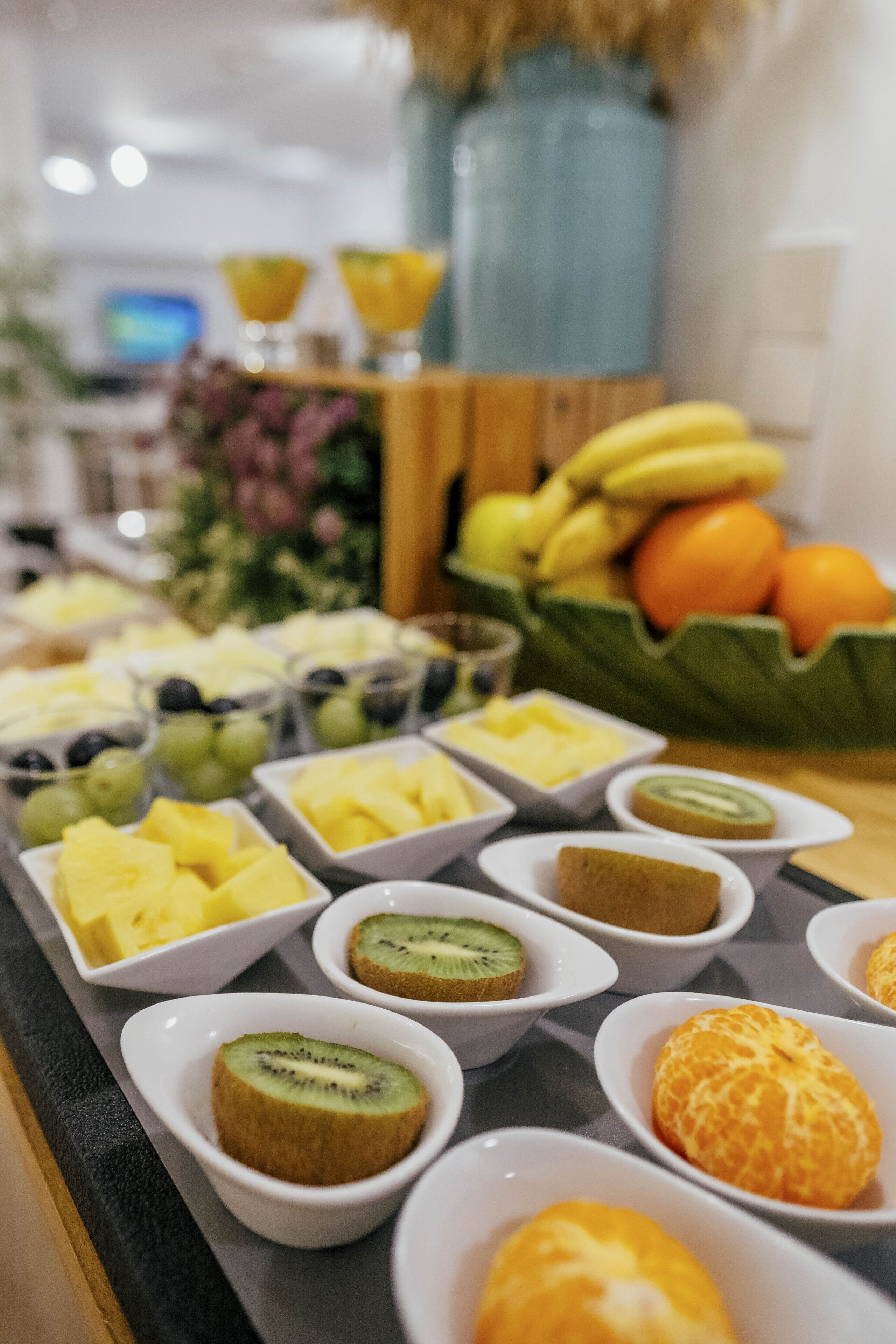A buffet with various fruits and desserts in bowls.