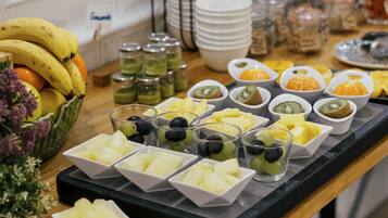A buffet table with various fruits and snacks.