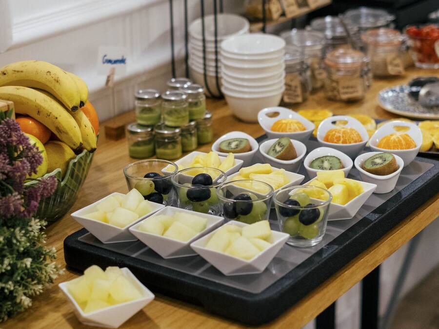 A buffet table with various fruits and snacks.