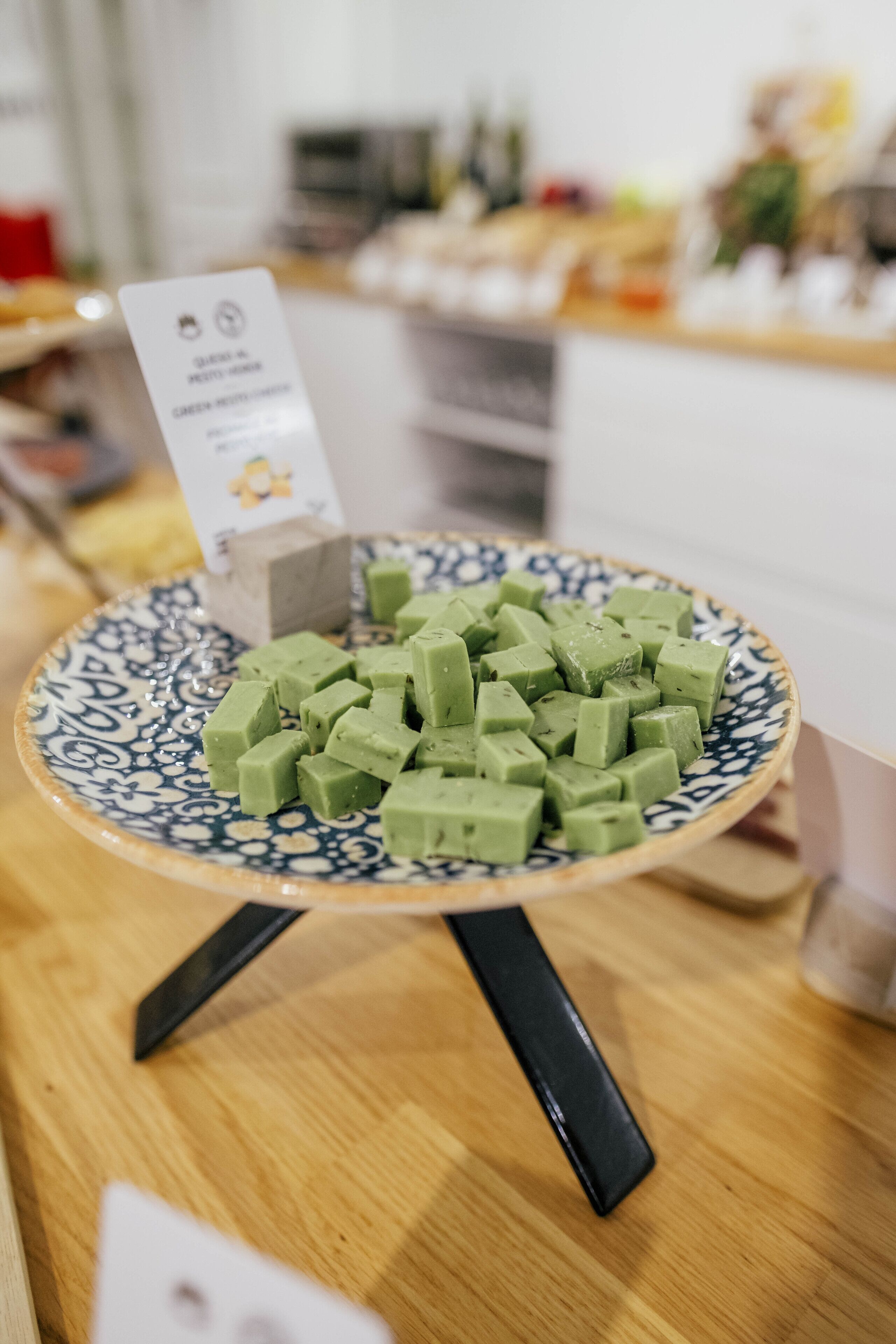 Une assiette remplie de cubes verts, posée sur un présentoir décoratif.