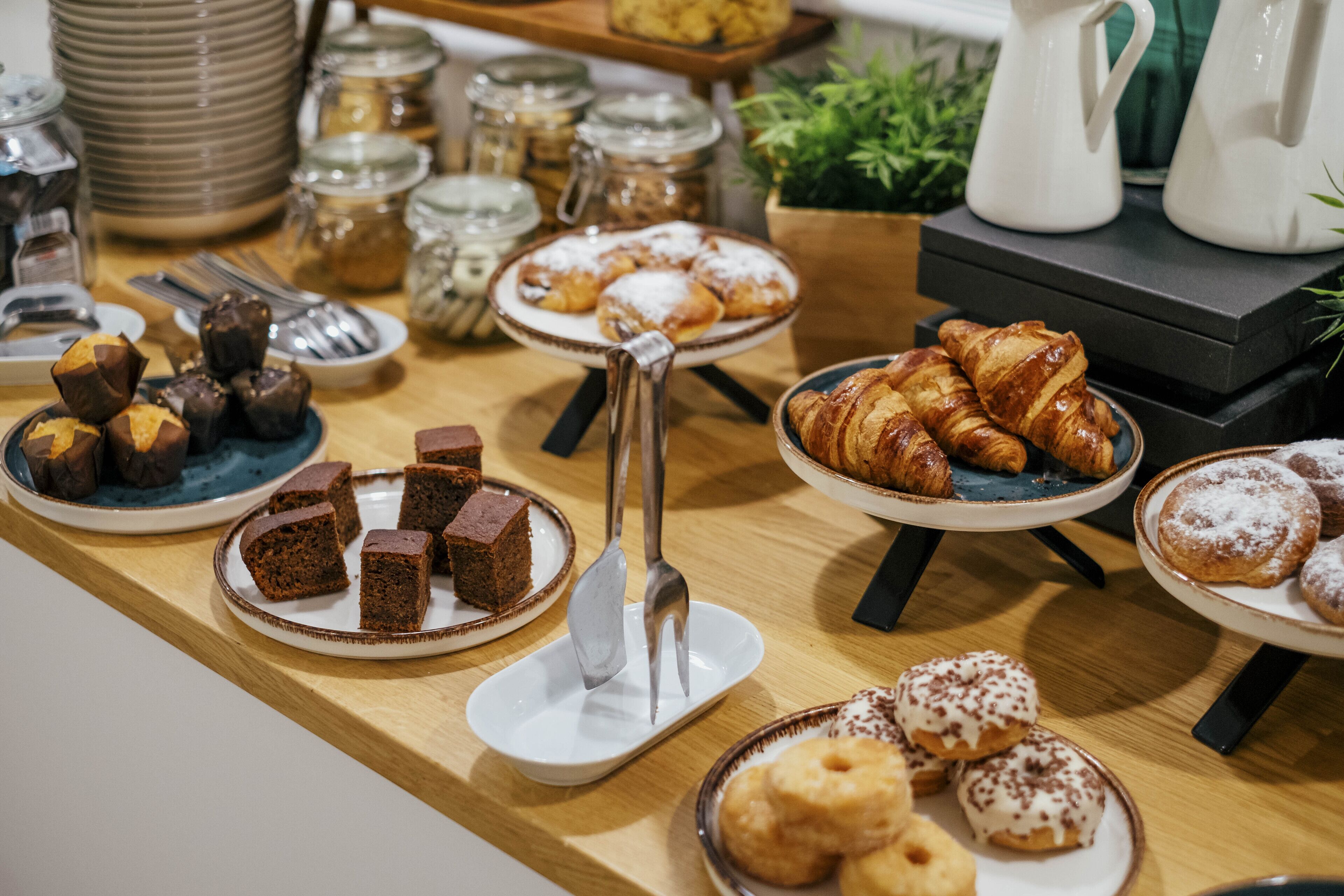 A buffet table with various desserts and pastries.