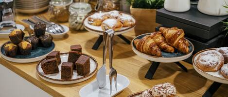A buffet table with various desserts and pastries.
