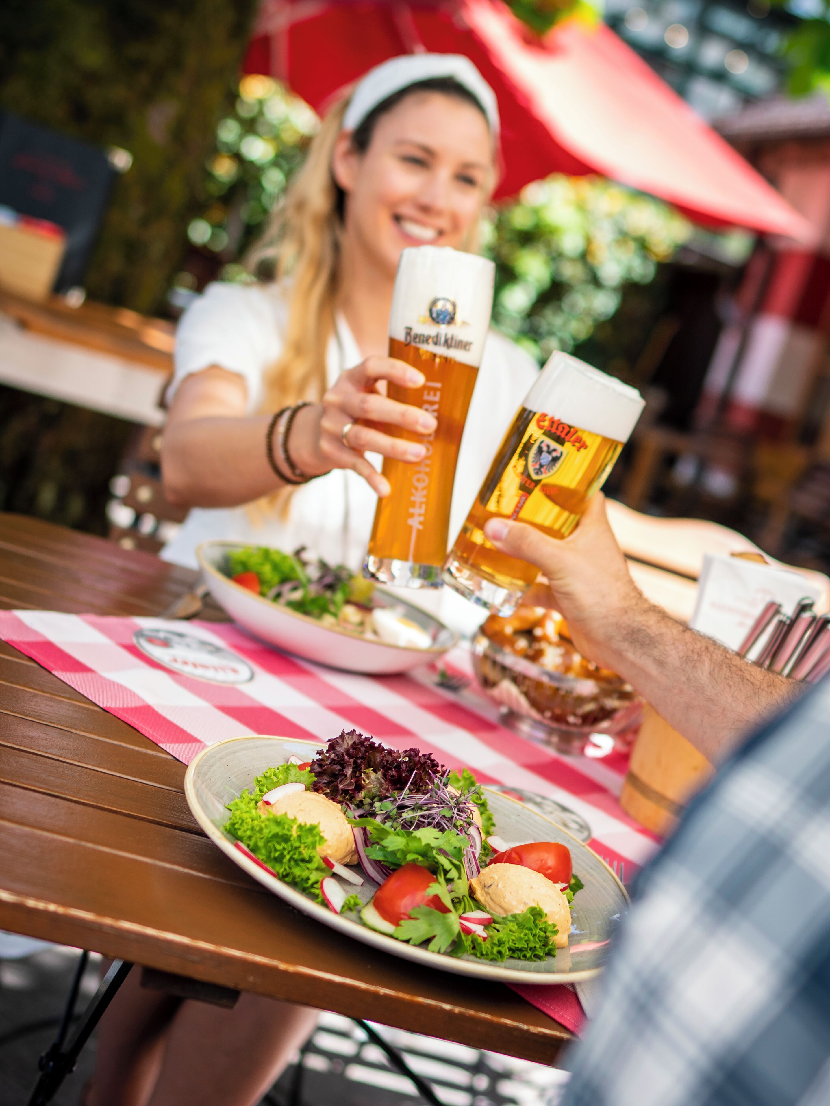 A dining table with a plate of food and two beer glasses.