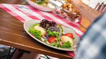 A dining table with a plate of food and two beer glasses.