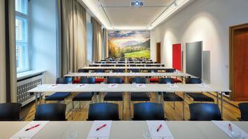 A conference room with a long table, chairs, and a projector screen.
