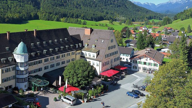 Un hôtel doté d’une tour, d’une cour intérieure et surplombant un paysage montagneux.