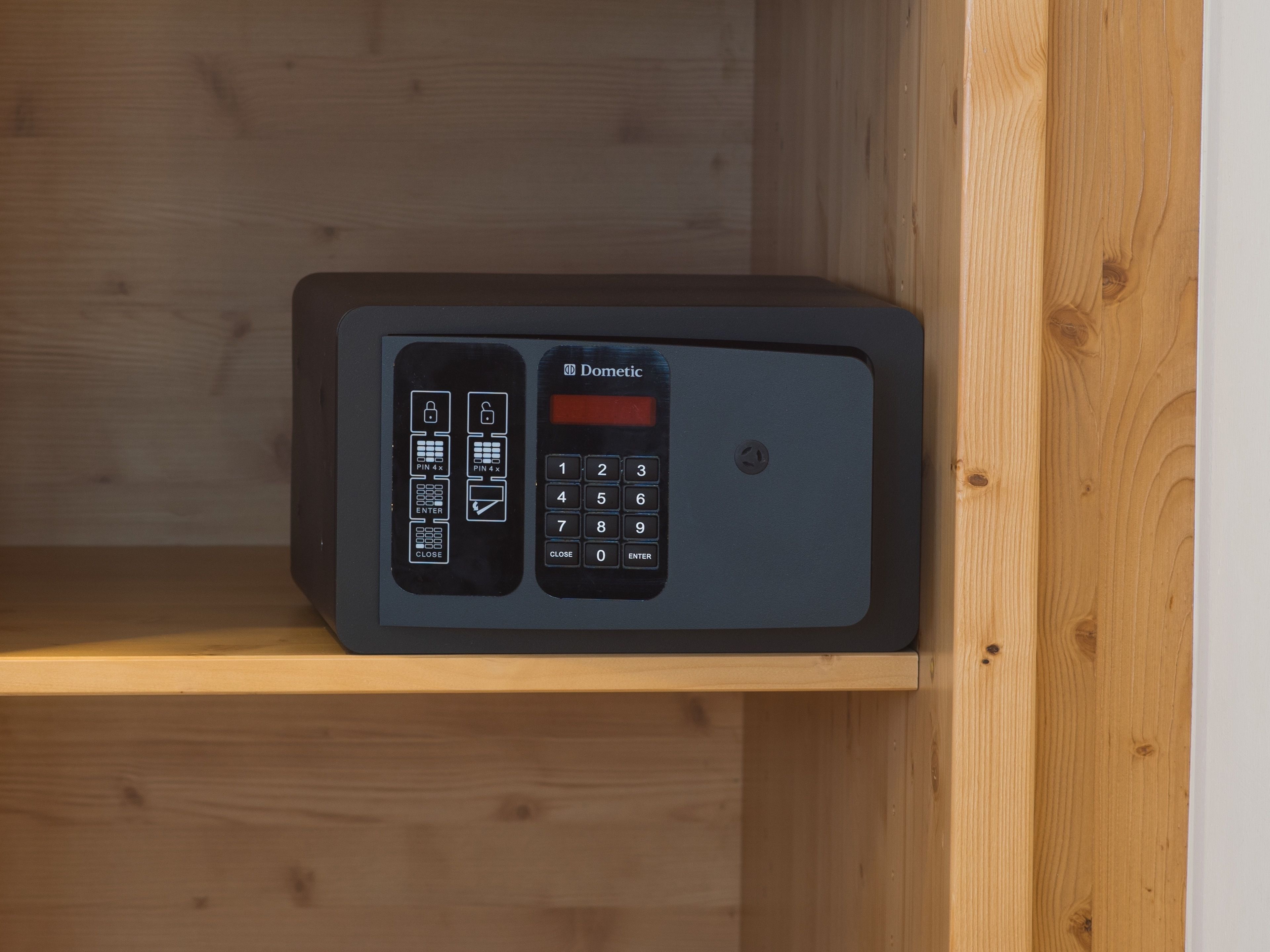 Un clavier de sécurité doté d’un emplacement pour la saisie d’un code PIN et d’un pavé numérique, placé sur une étagère en bois.