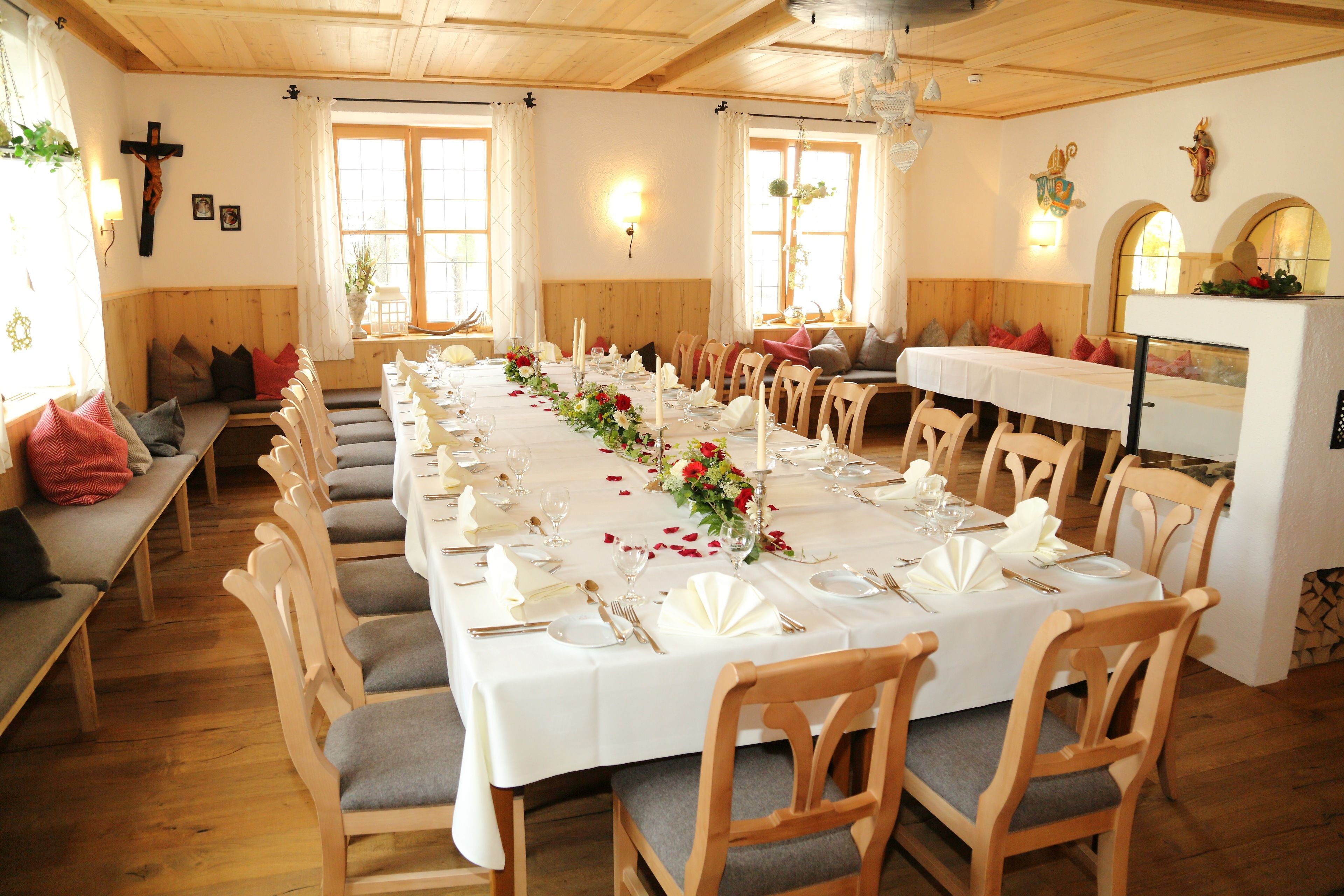 A long dining table set for a meal in a room with wooden walls and benches.