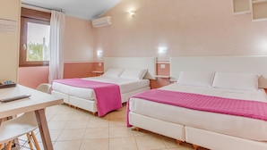 Habitación de hotel con dos camas, un escritorio, una ventana con cortinas, aire acondicionado y un estante en la pared.