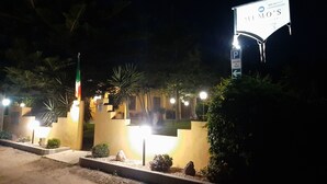 Vista nocturna de un edificio con un cartel que indica restaurante de desayunos.