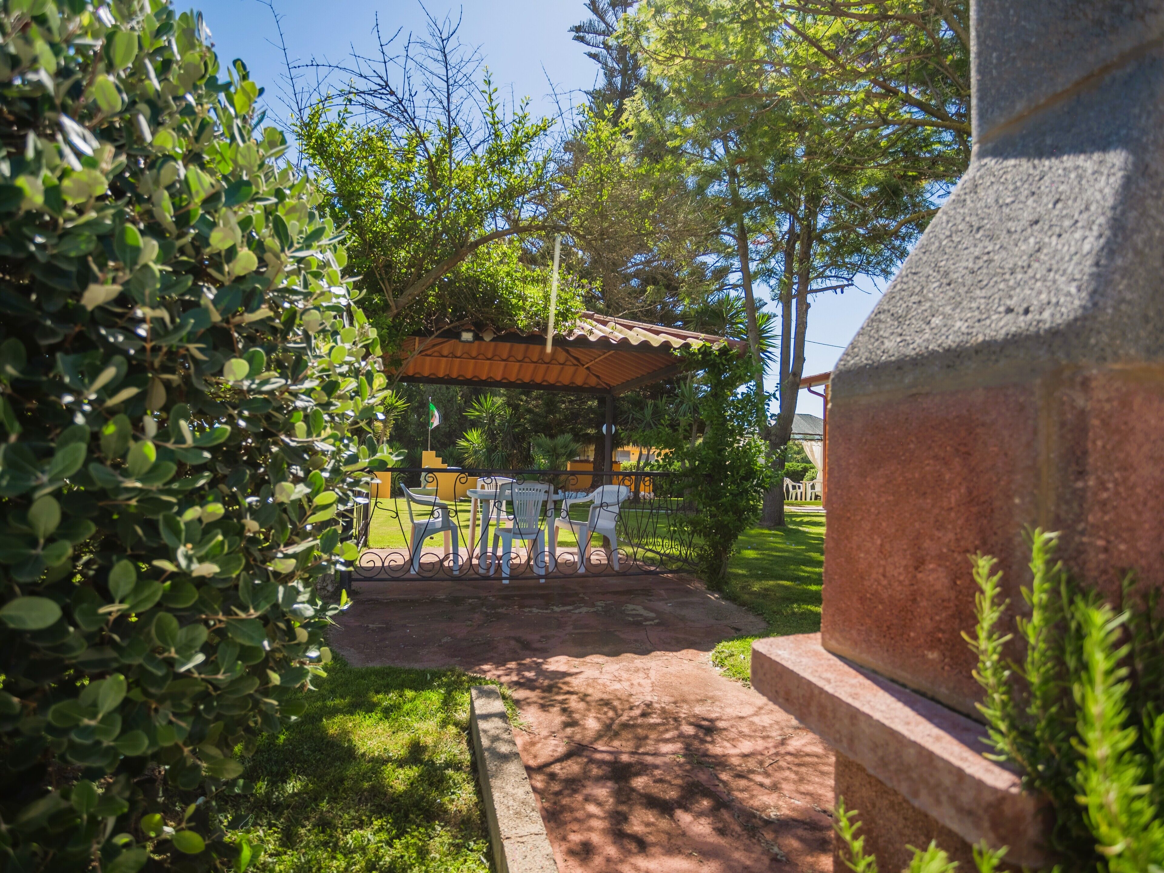 A patio area with outdoor seating, a covered structure, and a stone wall.