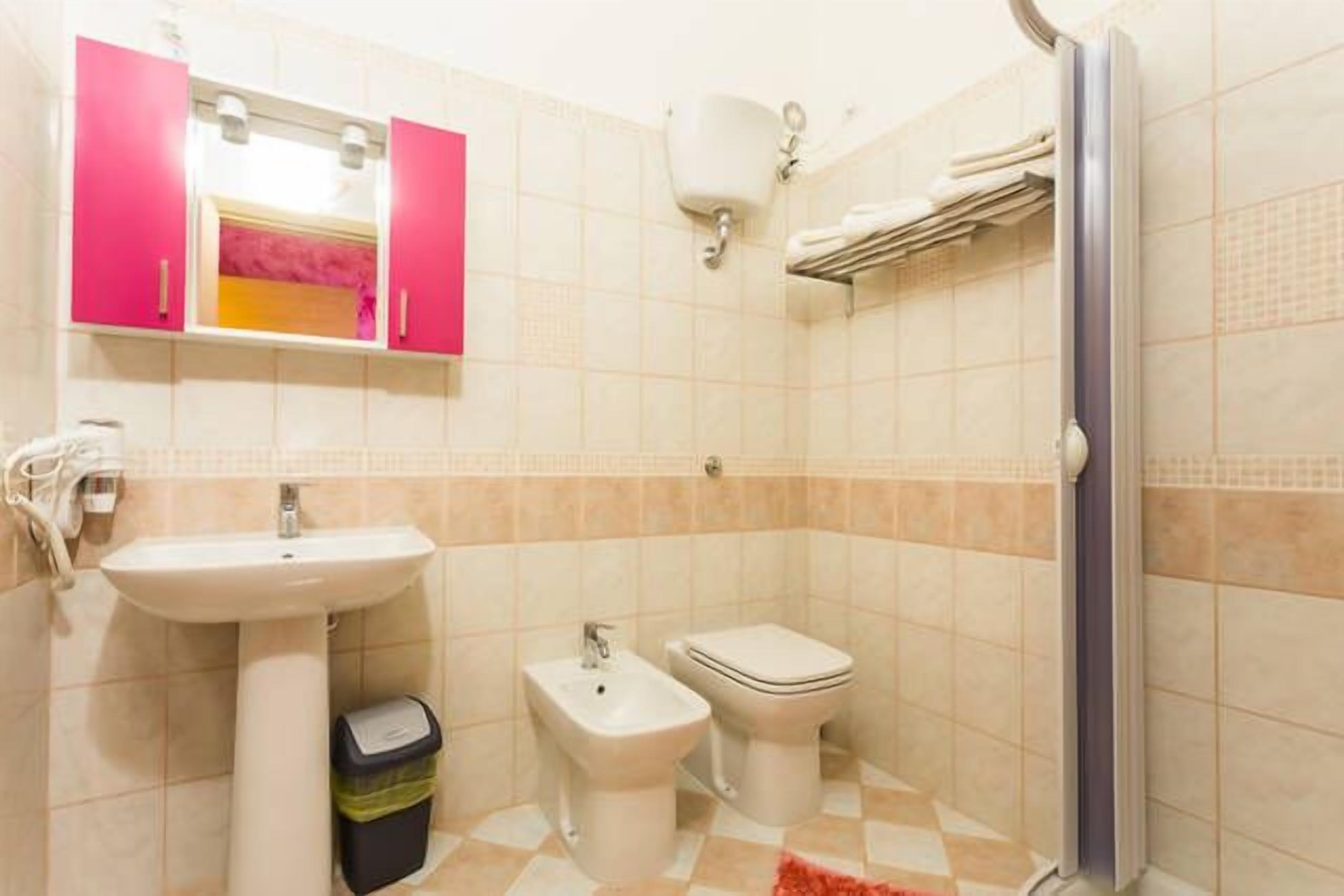 Un baño con lavamanos, bidé, inodoro y cabina de ducha.