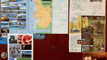 A bulletin board with various travel-related materials pinned to it, including maps, brochures, and informational posters.