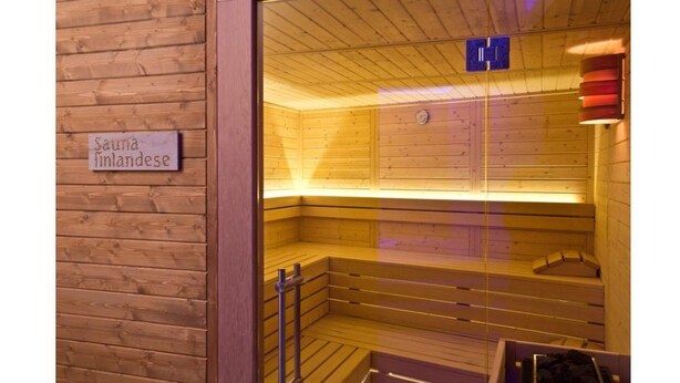 Un cuarto de sauna con paredes y bancos de madera.