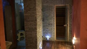 Un pasillo con pared de ladrillo y puerta de madera.