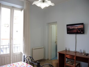 Relax in a cozy space with a comfortable bed, TV, and desk area.