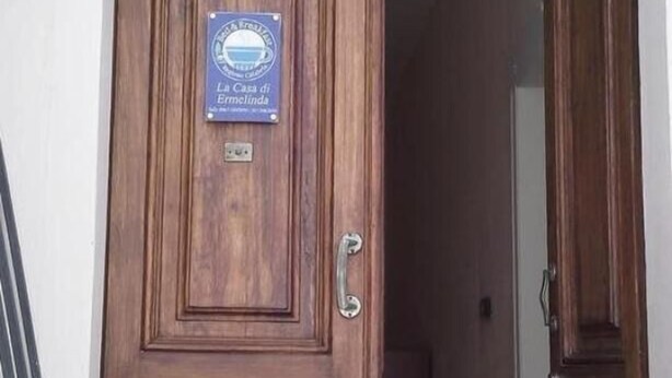 A wooden door with a plaque, a handle, and a keyhole. - La Casa di Ermelinda (Reggio Calabria)