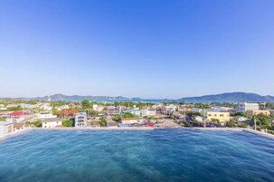 Una piscina al aire libre, sillones reclinables de piscina