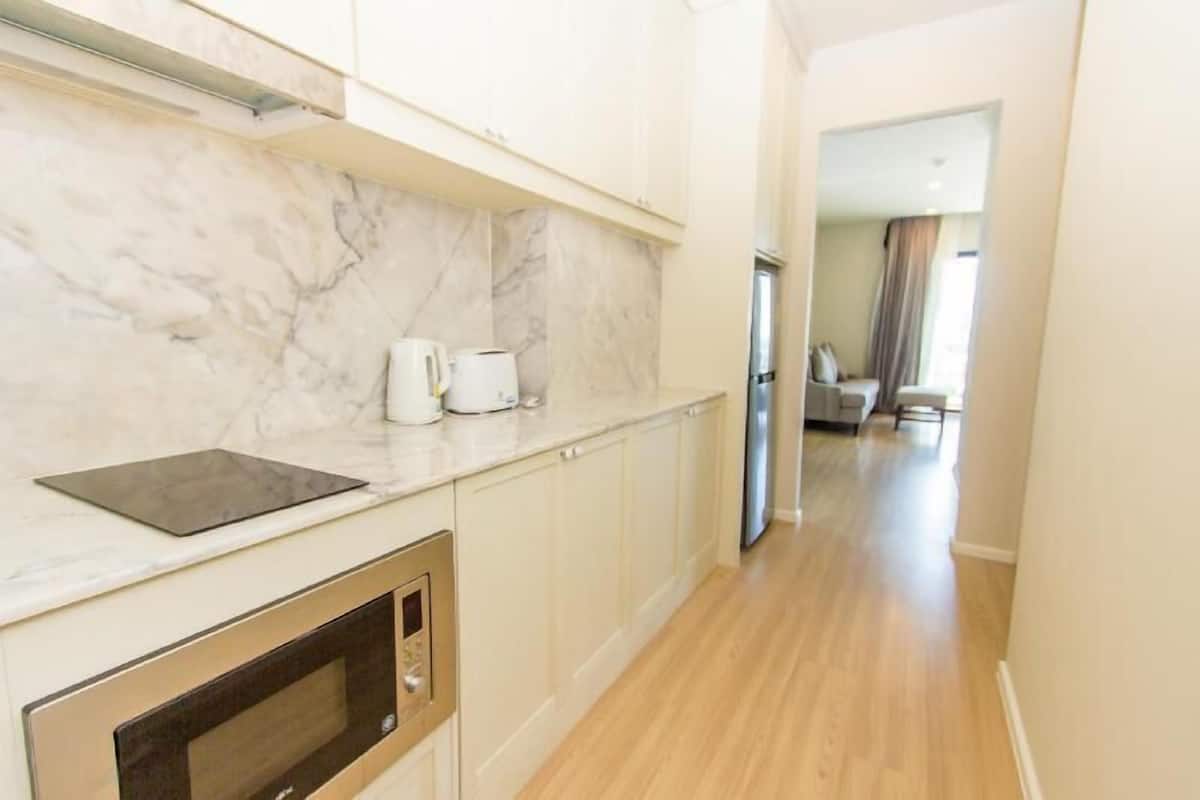 A kitchen with marble backsplash, a built-in oven, and a coffee maker.