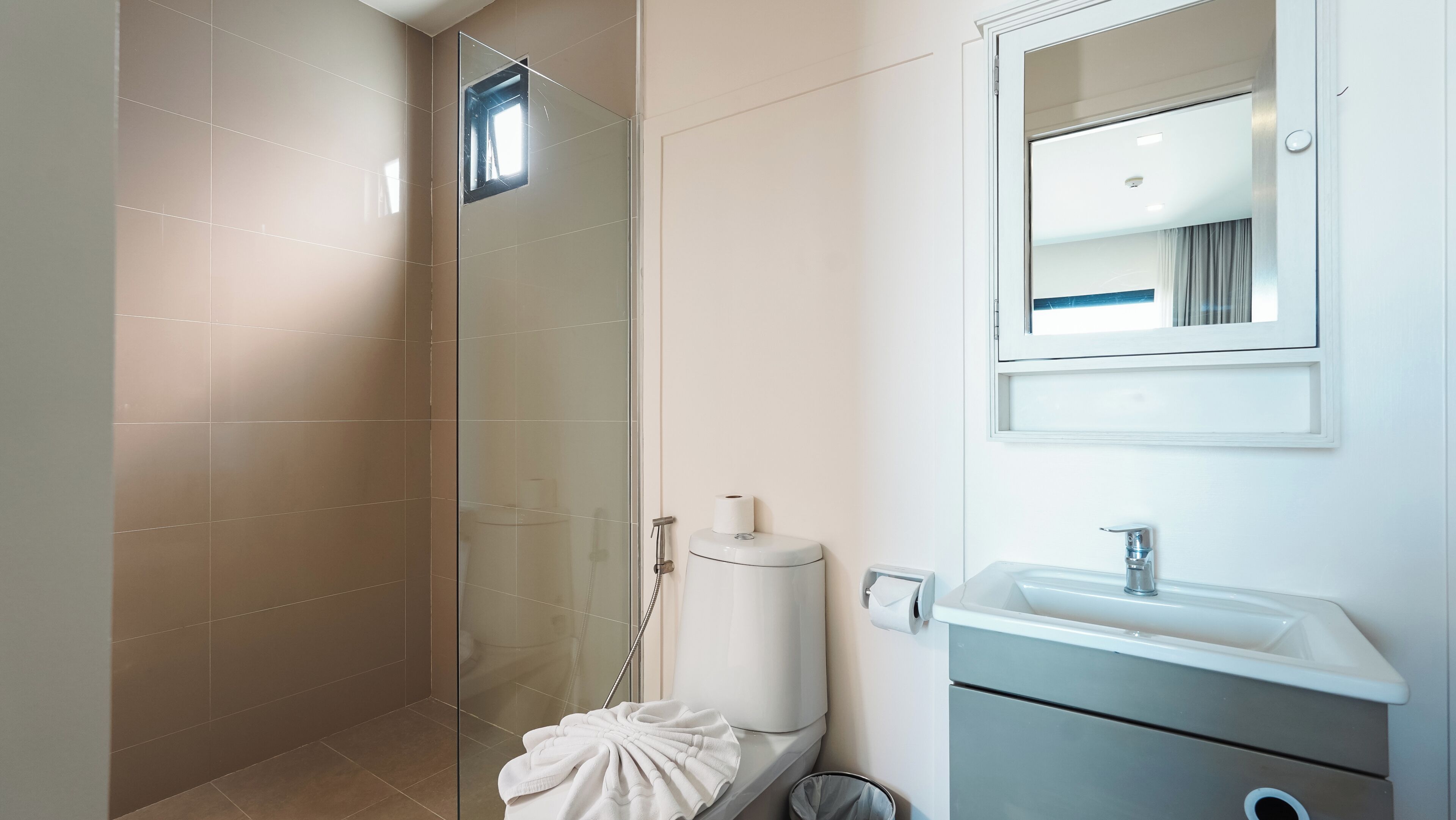 Ein modernes Badezimmer mit einer Duschkabine aus Glas, einer Toilette und einem Waschbecken.