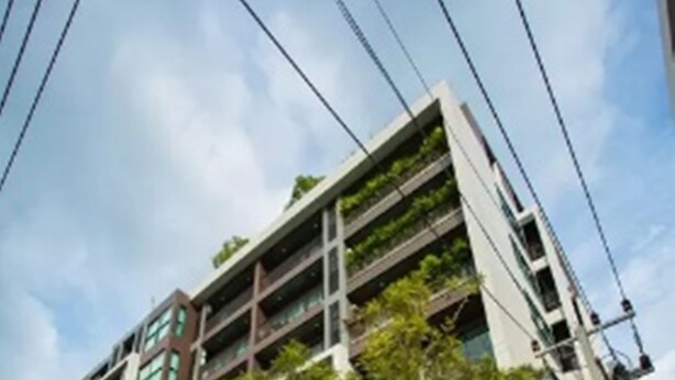 A modern building with a sign reading "DLUX". - Dlux Condominium (Chalong)