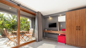 Una cocina moderna con televisor, armarios de madera y un comedor con sillas y mesa.