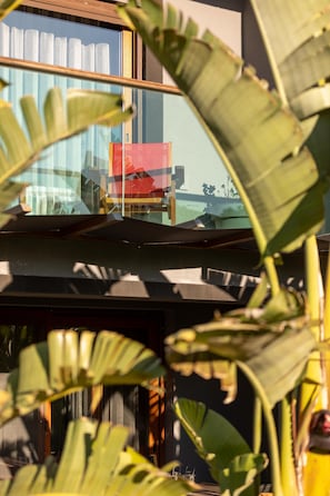 Un edificio moderno con ventanas grandes y vista a un edificio rojo al otro lado de la calle.