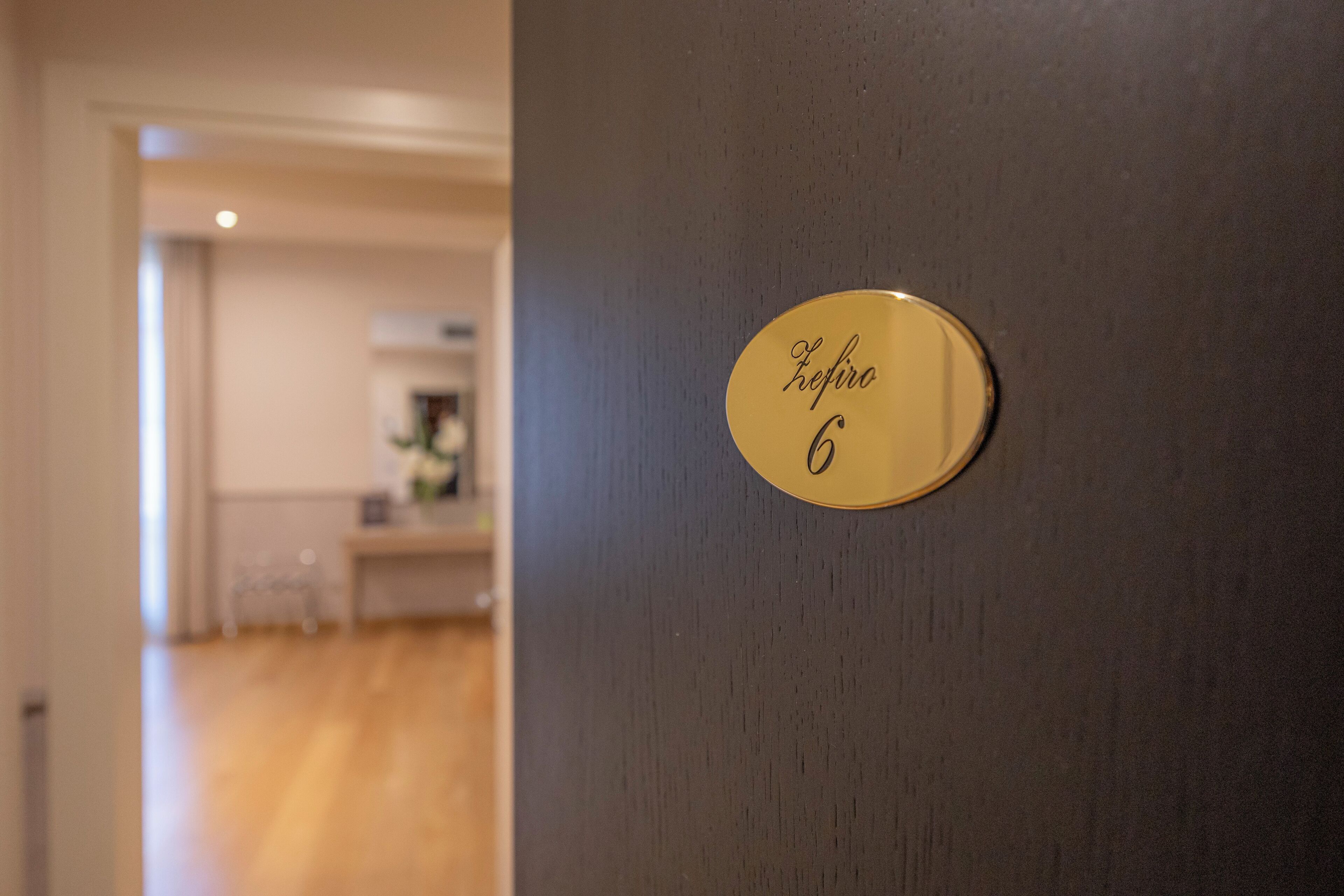 A door with a gold plaque reading "Kefiro 6" on a dark wall.