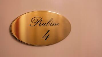 A gold-colored plaque with the name "Rubino" and the number "4" on a wall.