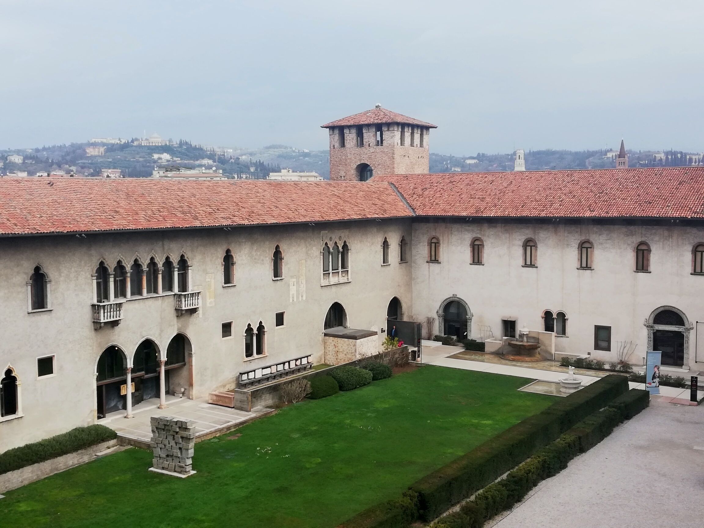 Un bâtiment historique doté d’une cour intérieure, de fenêtres en arc de cercle et d’une tour.