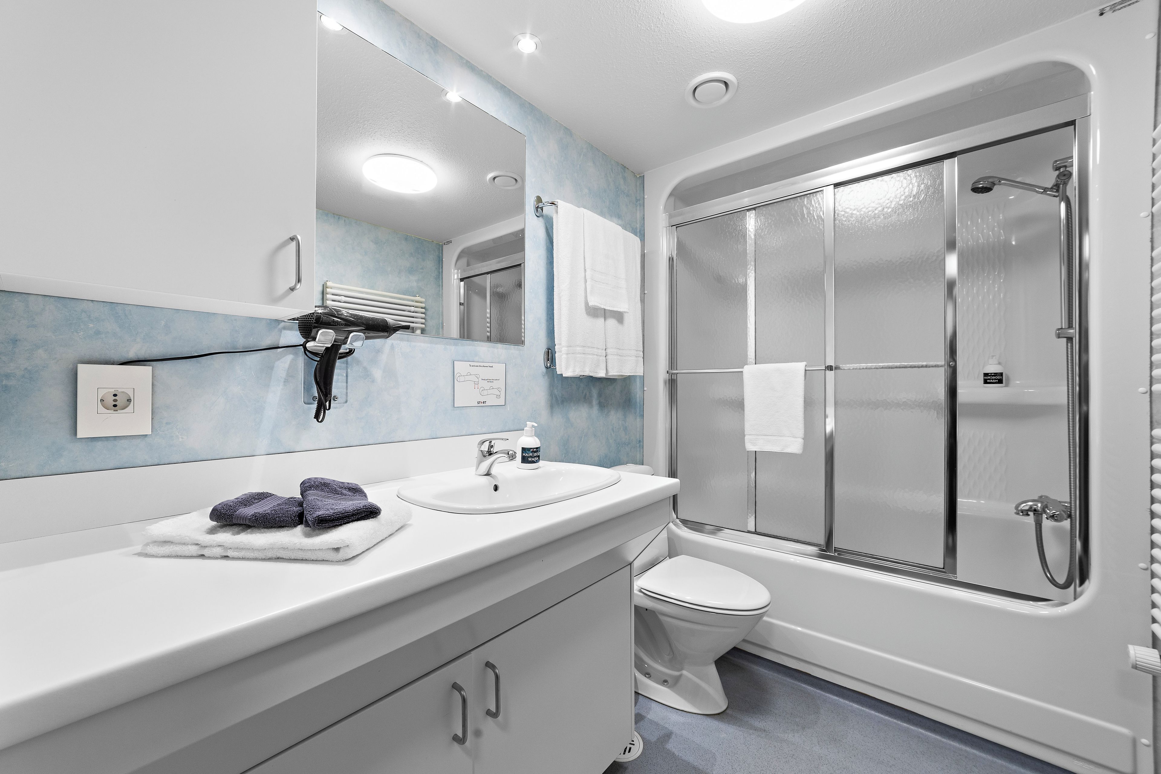 A modern bathroom with a bathtub, a toilet, and a sink.
