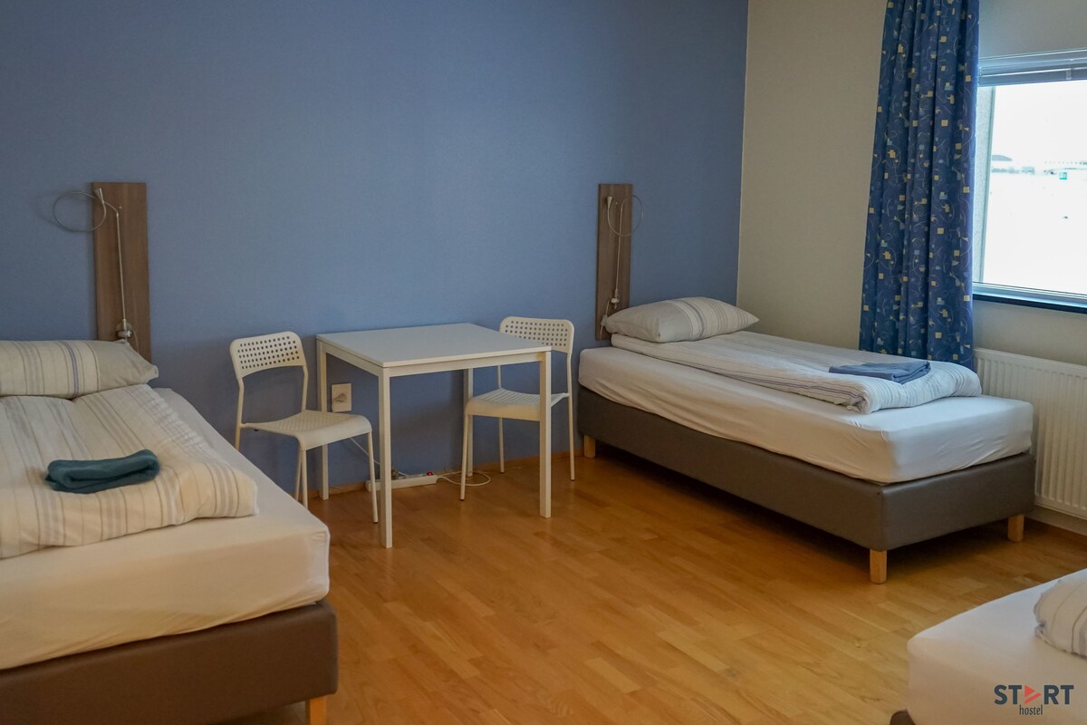 A room with two beds, a small table, and chairs.