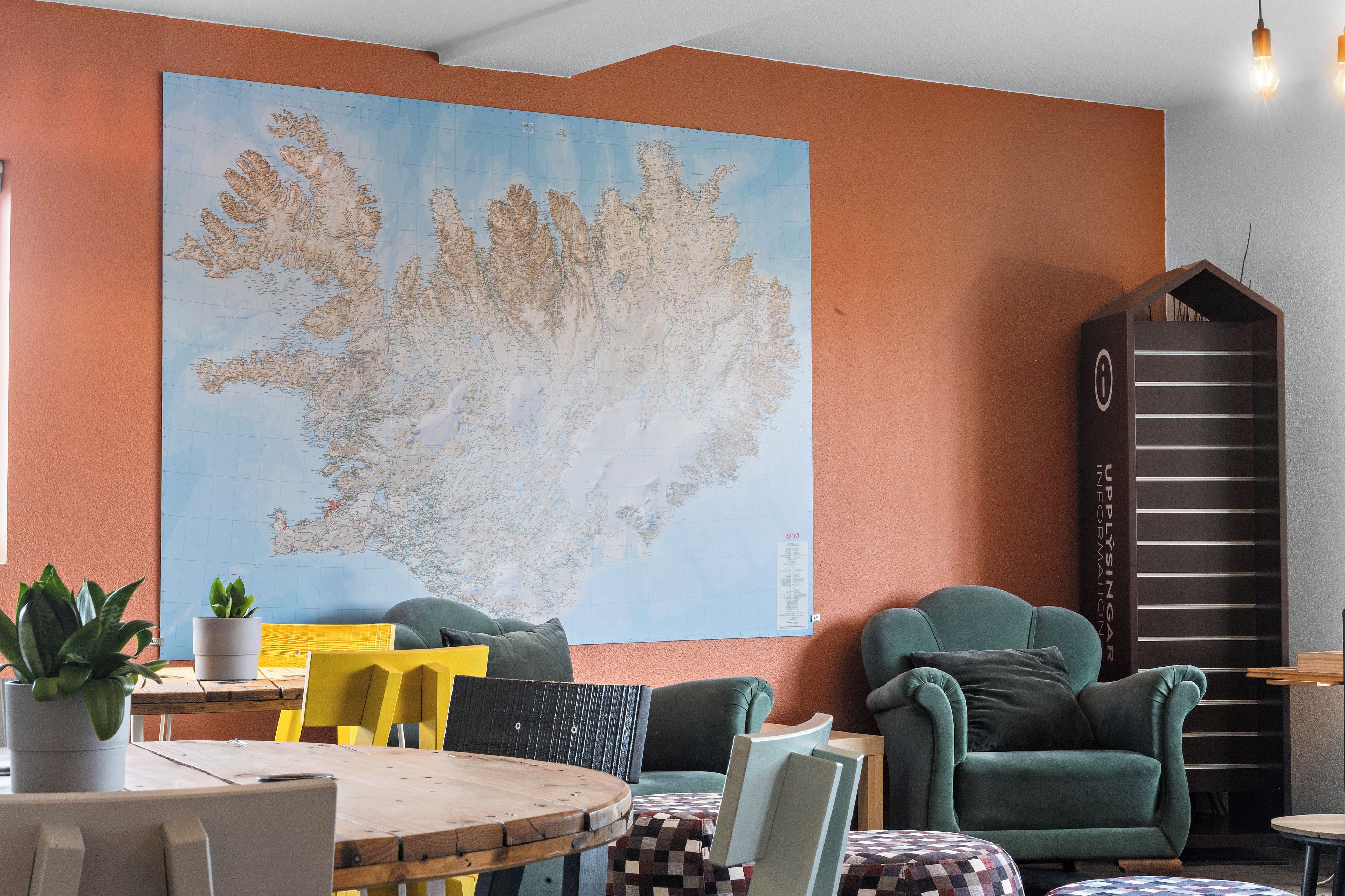 A modern interior with a large map on the wall, seating arrangements, and a tall information stand.