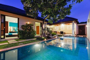 A modern house with a swimming pool, a well-maintained garden, and a patio area. - Samana Villas (Legian)
