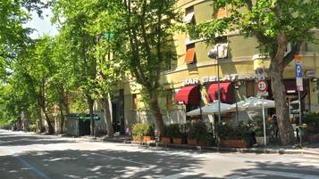 Una vista di strada con un edificio con la scritta "BAR GATE" e un cartello "LIDO", che indica un ristorante o un caffè.