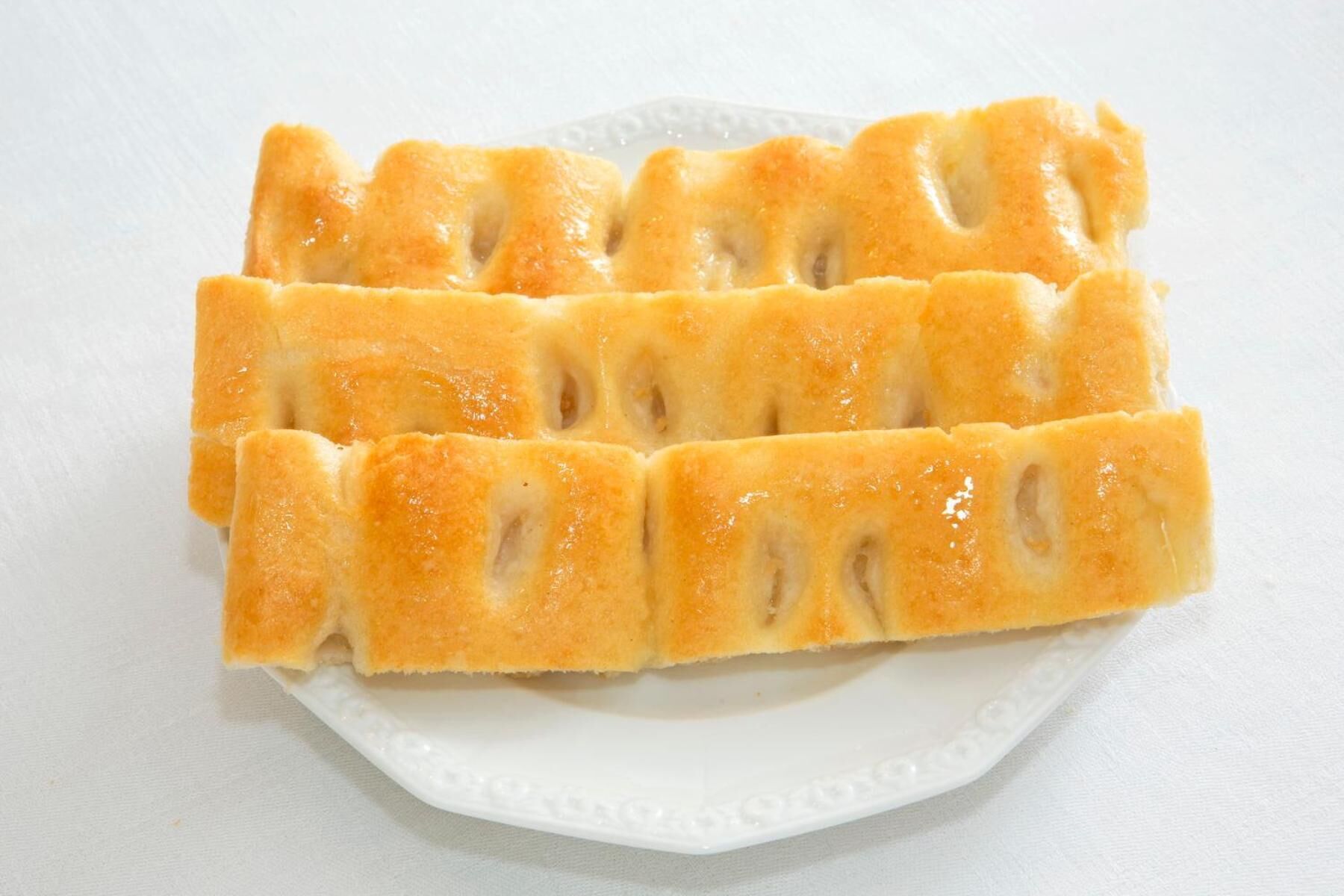 A white plate with several pieces of bread.