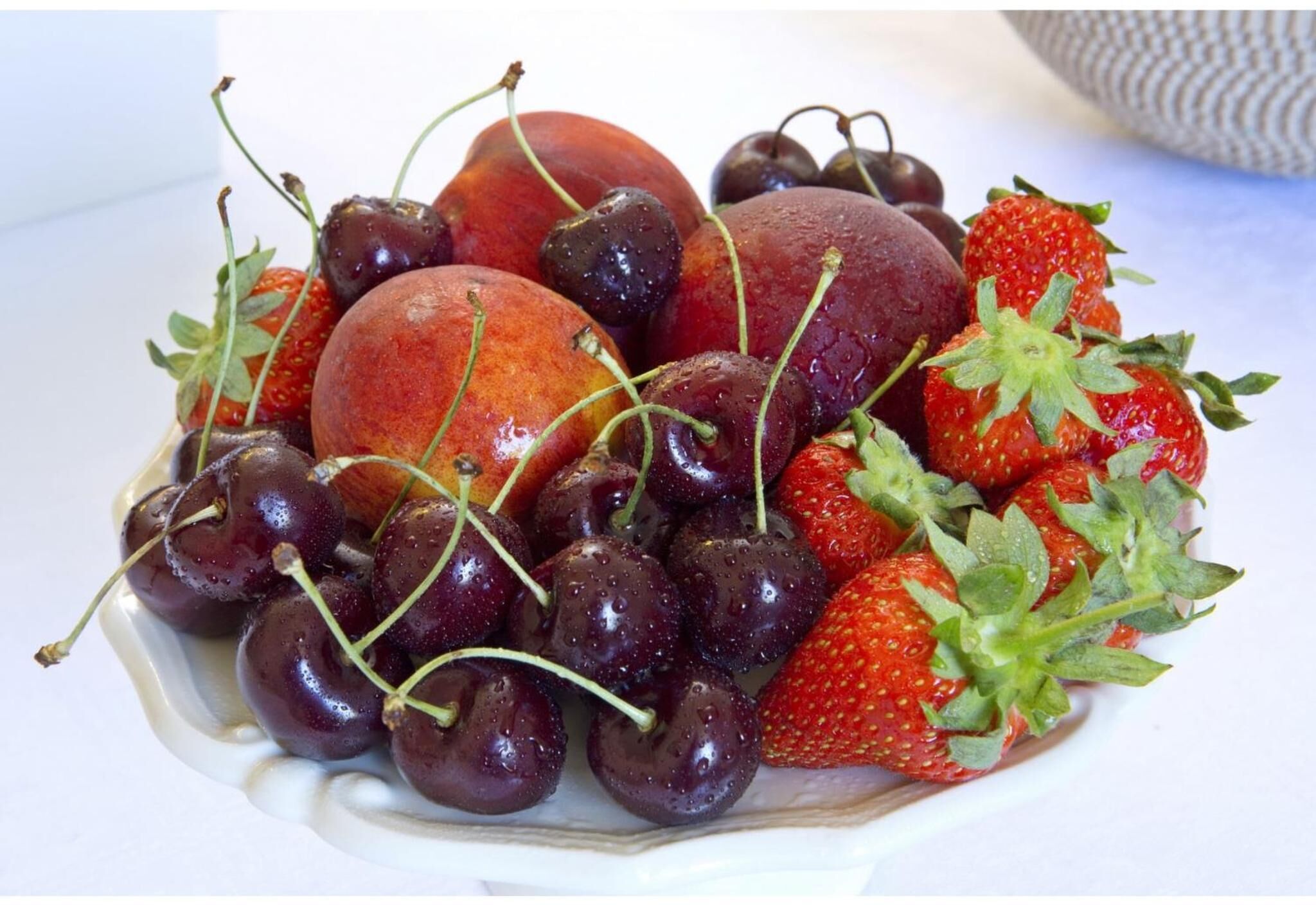 A plate of fresh strawberries and cherries.