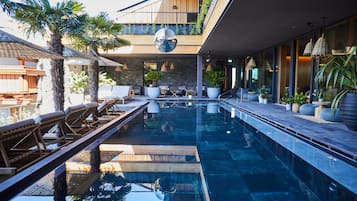 Relax by the pool surrounded by lush greenery and modern architecture.