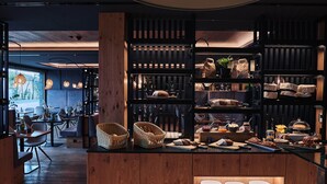 A buffet area with various food items and a seating area with tables and chairs. - Hotel Gerl (Wals-Siezenheim)