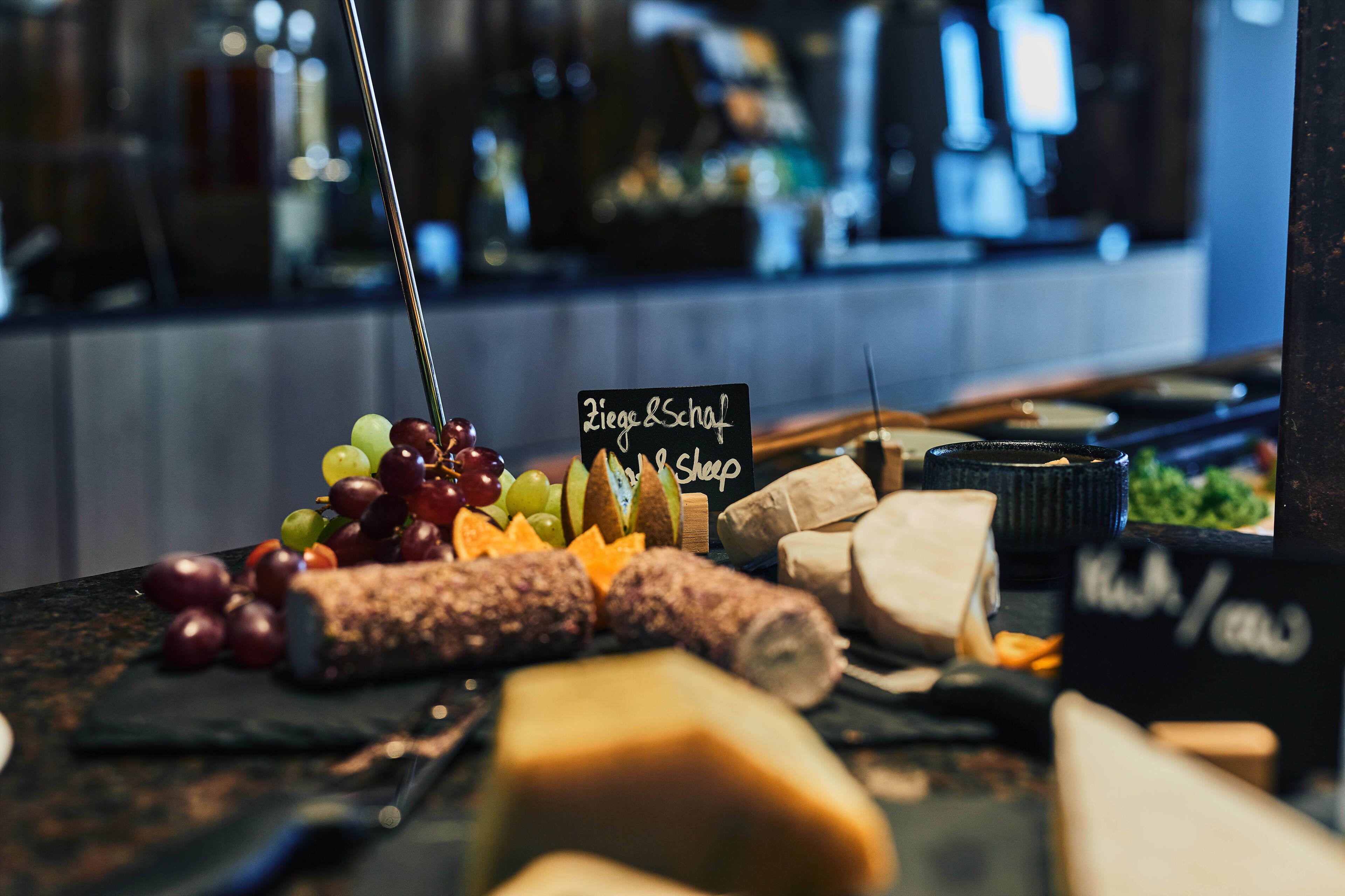 A charcuterie board with various cheeses, fruits, and meats.