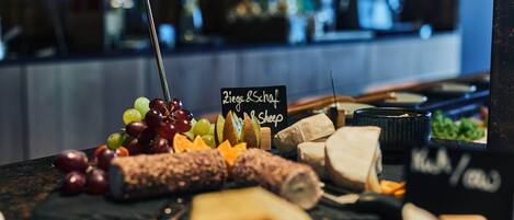 A charcuterie board with various cheeses, fruits, and meats.